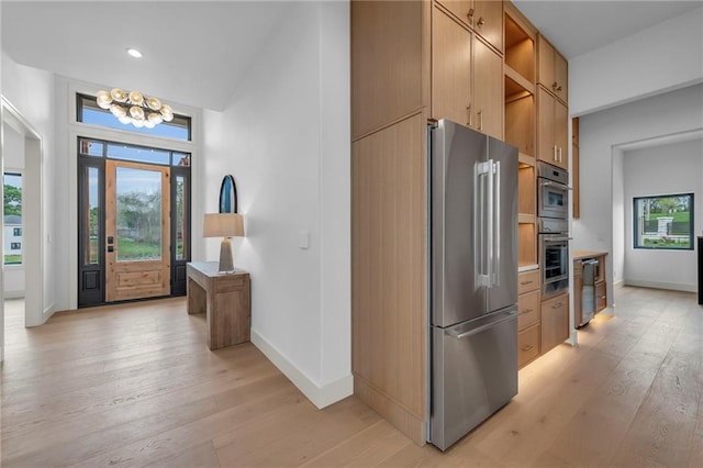 kitchen featuring appliances with stainless steel finishes, light wood-type flooring, and open shelves