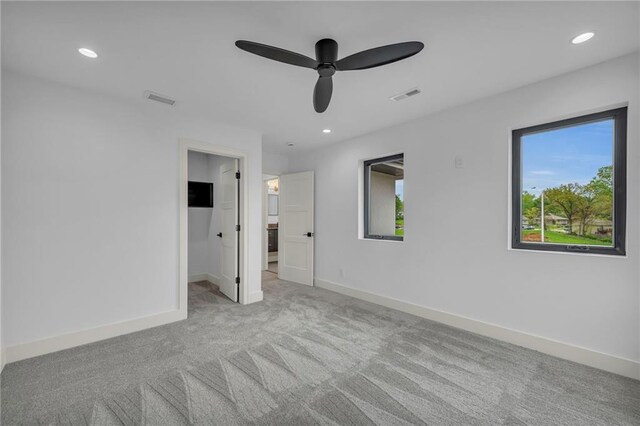 unfurnished bedroom with baseboards, visible vents, a walk in closet, and carpet flooring