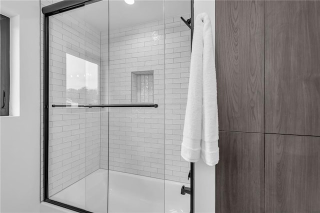 bathroom with bath / shower combo with glass door