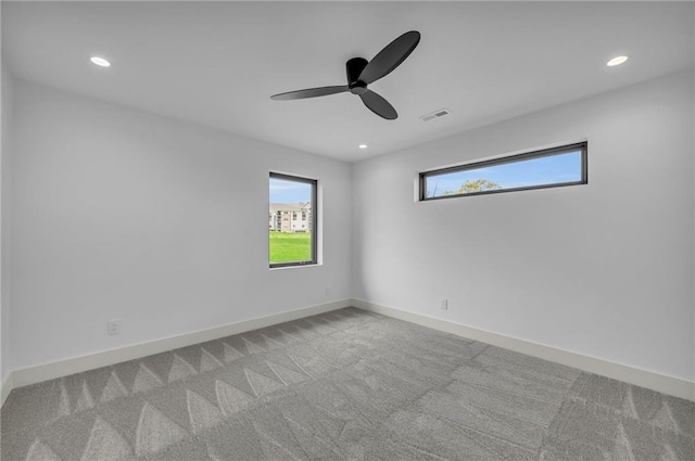 carpeted empty room featuring recessed lighting, a ceiling fan, visible vents, and baseboards
