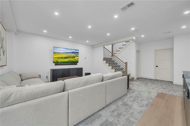 living area with recessed lighting, stairs, visible vents, and light carpet