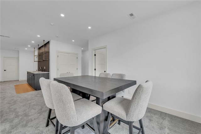 dining room featuring recessed lighting, visible vents, light colored carpet, and baseboards