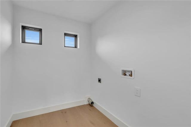 laundry room featuring electric dryer hookup, baseboards, hookup for a washing machine, light wood finished floors, and laundry area