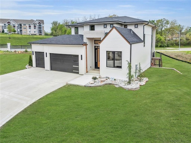 view of front of house featuring a front yard, stucco siding, driveway, and an attached garage