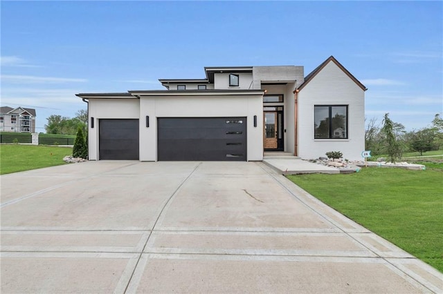 view of front of property featuring stucco siding, a front yard, and a garage