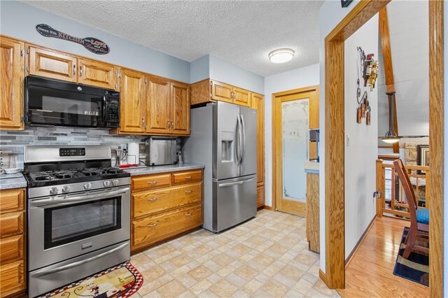 4012 NE Brooktree Ln, Kansas City, MO 64119 - kitchen with tasteful backsplash, light countertops, appliances with stainless steel finishes, and baseboards