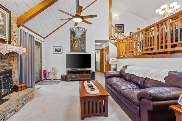 4012 NE Brooktree Ln, Kansas City, MO 64119 - carpeted living room featuring a stone fireplace, beam ceiling, ceiling fan with notable chandelier, high vaulted ceiling, and stairs