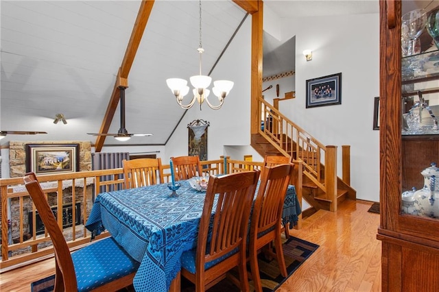4012 NE Brooktree Ln, Kansas City, MO 64119 - dining space featuring wood finished floors, an inviting chandelier, lofted ceiling with beams, and stairs