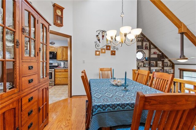 4012 NE Brooktree Ln, Kansas City, MO 64119 - dining room with light wood-style flooring, vaulted ceiling with beams, and a chandelier