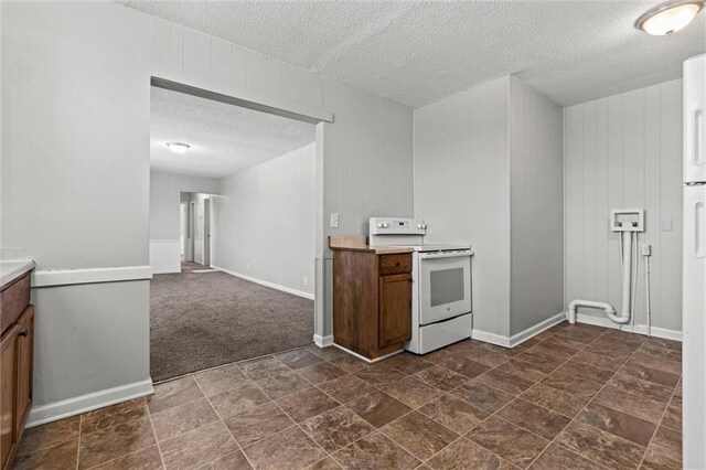 2701 Wilson Ave, Leavenworth, KS 66048 - kitchen with electric range, a textured ceiling, light countertops, baseboards, and dark stone finish flooring