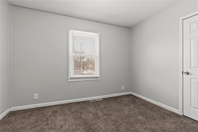 2701 Wilson Ave, Leavenworth, KS 66048 - empty room featuring dark carpet, baseboards, and a textured ceiling