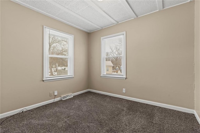 2701 Wilson Ave, Leavenworth, KS 66048 - spare room featuring plenty of natural light, dark colored carpet, and baseboards