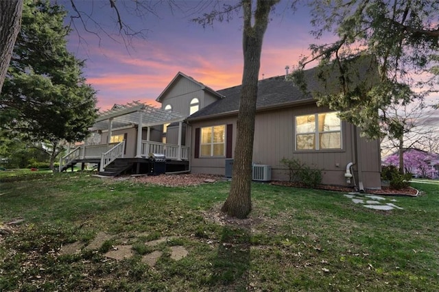 9708 Walnut Woods Dr, Kansas City, MO 64139 - view of front of house featuring roof with shingles, central AC unit, a pergola, a deck, and a yard