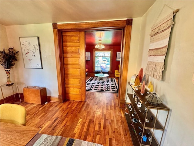 3640 Forest Ave, Kansas City, MO 64109 - corridor with wood finished floors, baseboards, and a chandelier