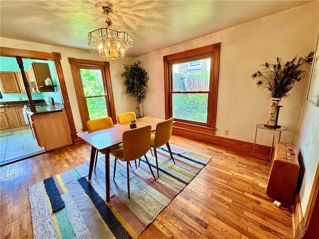 3640 Forest Ave, Kansas City, MO 64109 - dining room featuring light wood-style flooring, a chandelier, and baseboards