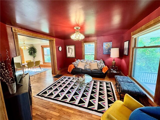 3640 Forest Ave, Kansas City, MO 64109 - living room with a chandelier, plenty of natural light, wood finished floors, and baseboards