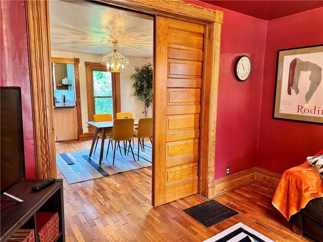 3640 Forest Ave, Kansas City, MO 64109 - dining area with a chandelier, wood finished floors, and baseboards