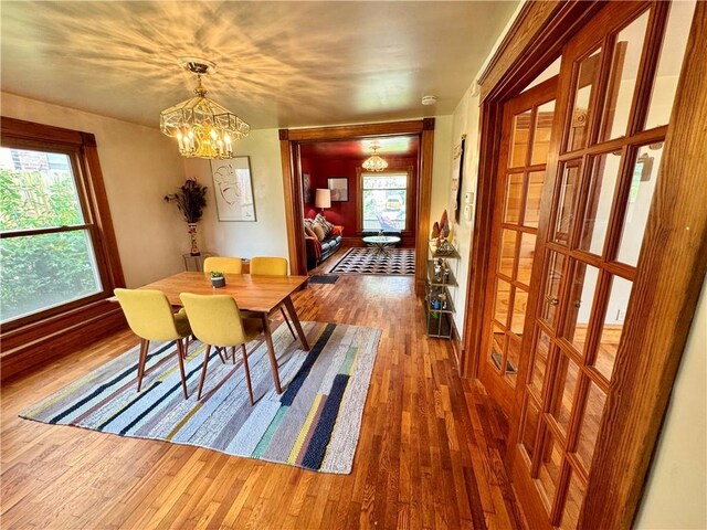 3640 Forest Ave, Kansas City, MO 64109 - dining room with wood finished floors, a chandelier, and plenty of natural light