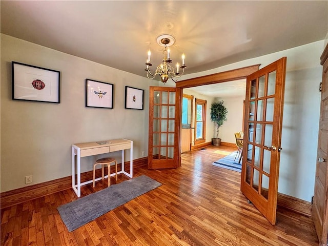 3640 Forest Ave, Kansas City, MO 64109 - dining room featuring french doors, a chandelier, wood finished floors, and baseboards