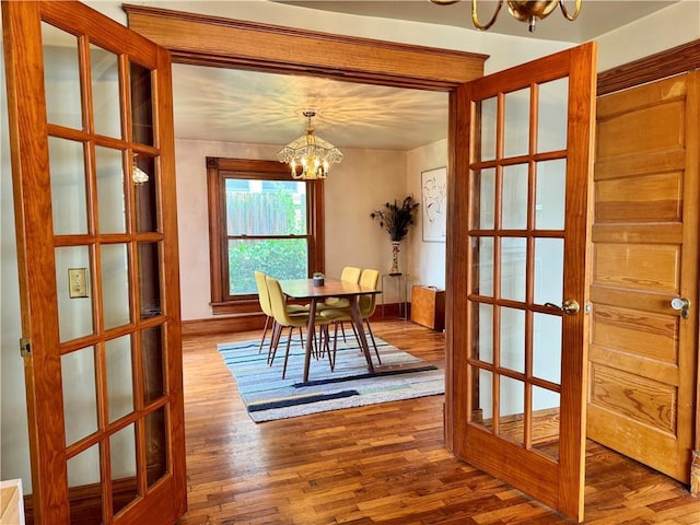 3640 Forest Ave, Kansas City, MO 64109 - dining area with a chandelier, wood finished floors, french doors, and baseboards