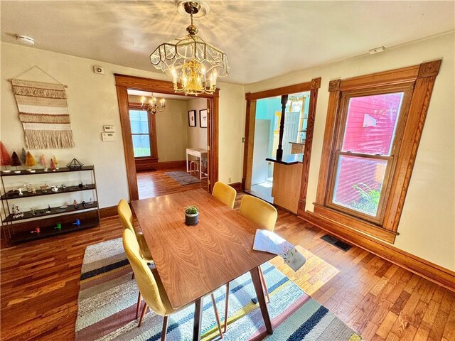 3640 Forest Ave, Kansas City, MO 64109 - dining space featuring a chandelier, baseboards, and wood finished floors