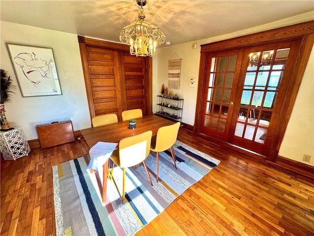 3640 Forest Ave, Kansas City, MO 64109 - dining space featuring a chandelier, wood finished floors, and baseboards