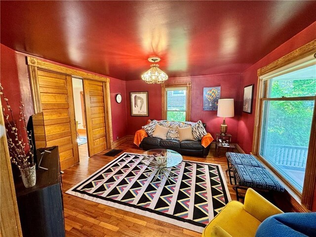 3640 Forest Ave, Kansas City, MO 64109 - living room with a chandelier, wood finished floors, and baseboards