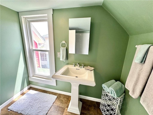 3640 Forest Ave, Kansas City, MO 64109 - bathroom featuring plenty of natural light, vaulted ceiling, and baseboards