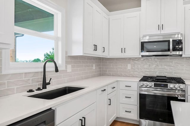 16470 W 166th Pl, Olathe, KS 66062 - kitchen with appliances with stainless steel finishes, a sink, light countertops, and white cabinetry
