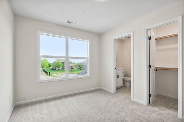 16470 W 166th Pl, Olathe, KS 66062 - unfurnished bedroom featuring a spacious closet, light colored carpet, baseboards, connected bathroom, and a closet