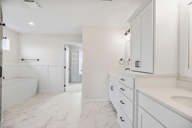 16470 W 166th Pl, Olathe, KS 66062 - bathroom featuring a freestanding tub, vanity, a wainscoted wall, marble look tiles, and a decorative wall