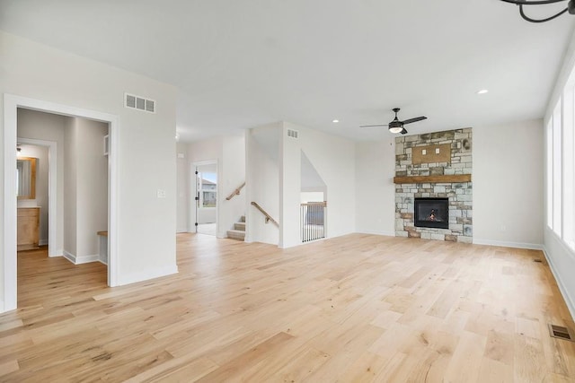 16470 W 166th Pl, Olathe, KS 66062 - unfurnished living room featuring light wood-style flooring, ceiling fan, stairway, a fireplace, and recessed lighting