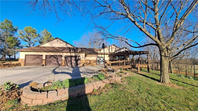 2101A Dove Rd, Longton, KS 67352 - view of front of home featuring concrete driveway, stucco siding, a deck, a front yard, and a garage