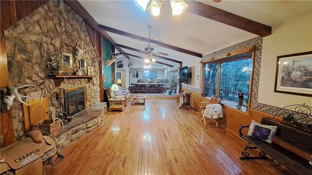 2101A Dove Rd, Longton, KS 67352 - living area with lofted ceiling with beams, a wainscoted wall, hardwood / wood-style flooring, a fireplace, and a ceiling fan