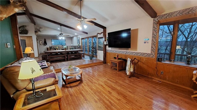 2101A Dove Rd, Longton, KS 67352 - living area featuring wooden walls, ceiling fan, wood finished floors, vaulted ceiling with beams, and wainscoting