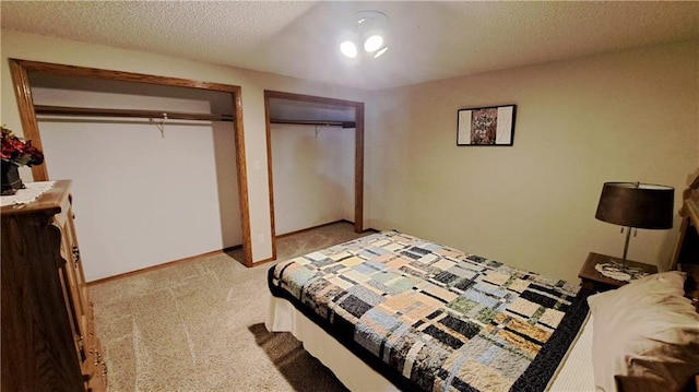 2101A Dove Rd, Longton, KS 67352 - bedroom featuring two closets, carpet floors, baseboards, and a textured ceiling