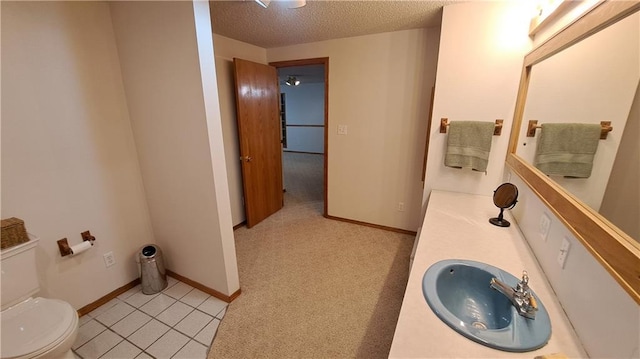 2101A Dove Rd, Longton, KS 67352 - bathroom with baseboards, a textured ceiling, toilet, and vanity