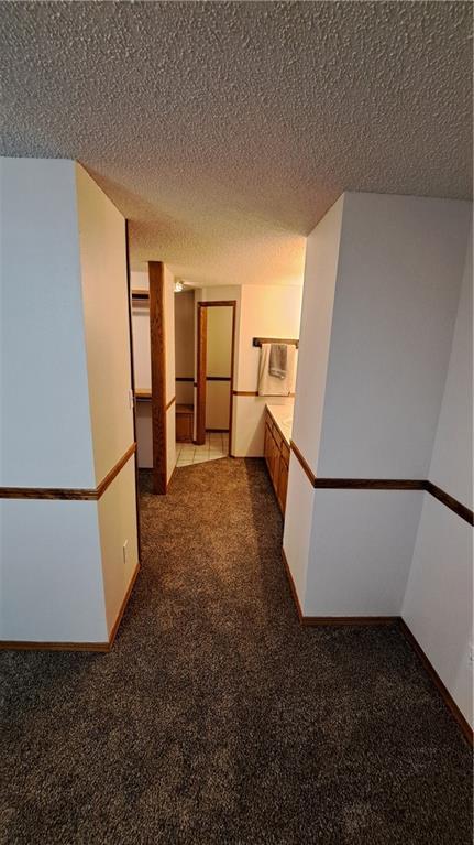 2101A Dove Rd, Longton, KS 67352 - corridor featuring a textured ceiling and carpet