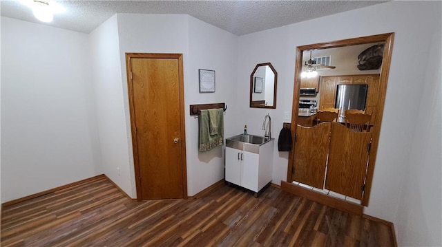 2101A Dove Rd, Longton, KS 67352 - laundry room featuring dark wood-style flooring, a textured ceiling, and a sink