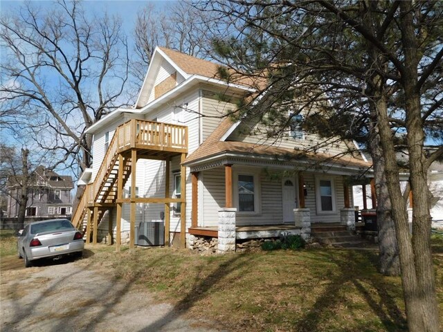 308 W 5th St, Pittsburg, KS 66762 - view of front of house featuring a shingled roof, central AC, stairs, and a porch