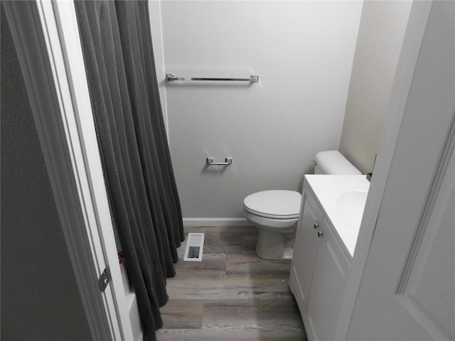 308 W 5th St, Pittsburg, KS 66762 - bathroom with vanity, toilet, baseboards, visible vents, and wood finished floors