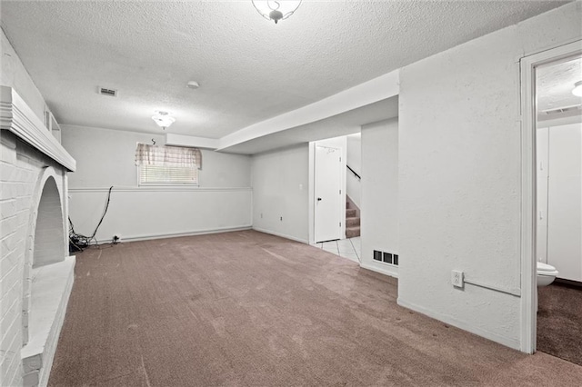 14404 Kansas Ave, Bonner Springs, KS 66012 - below grade area featuring a textured ceiling, carpet flooring, stairs, and a brick fireplace