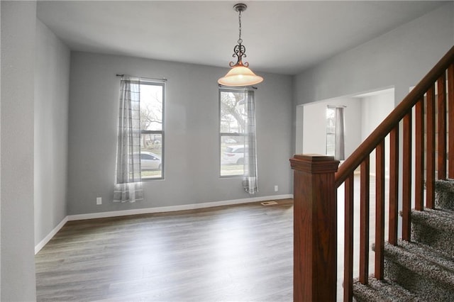 foyer entrance with visible vents, baseboards, stairs, and wood finished floors