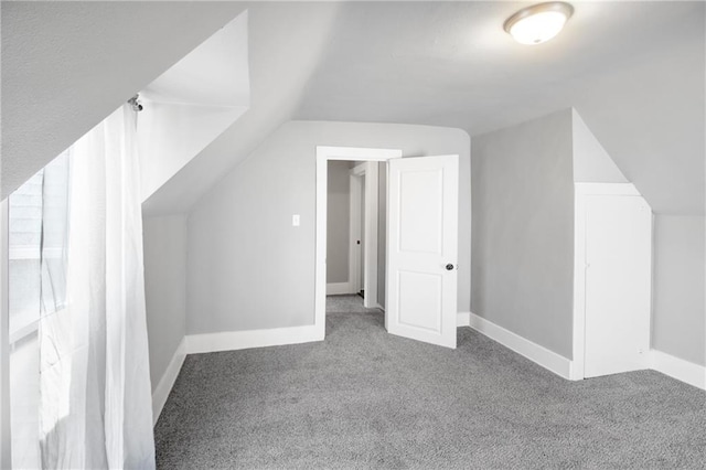 additional living space with carpet floors, baseboards, and lofted ceiling