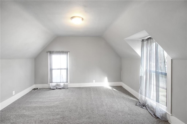 bonus room with baseboards, vaulted ceiling, and carpet flooring