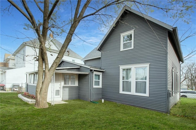 rear view of property with fence and a yard