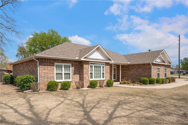 ranch-style house with brick siding and a shingled roof
