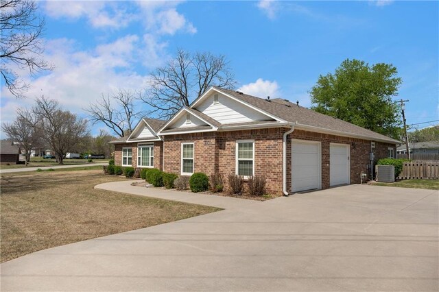 view of front of property with concrete driveway, a front lawn, fence, a garage, and brick siding