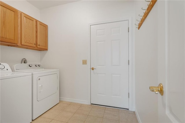 clothes washing area with cabinet space, washing machine and dryer, baseboards, and light tile patterned flooring