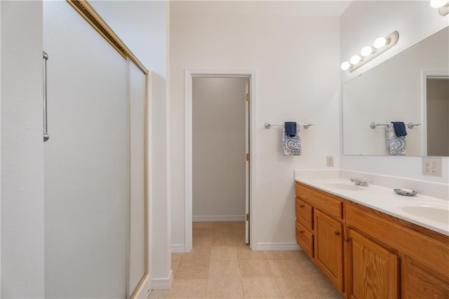 full bathroom featuring tile patterned floors, a shower with door, a sink, and double vanity